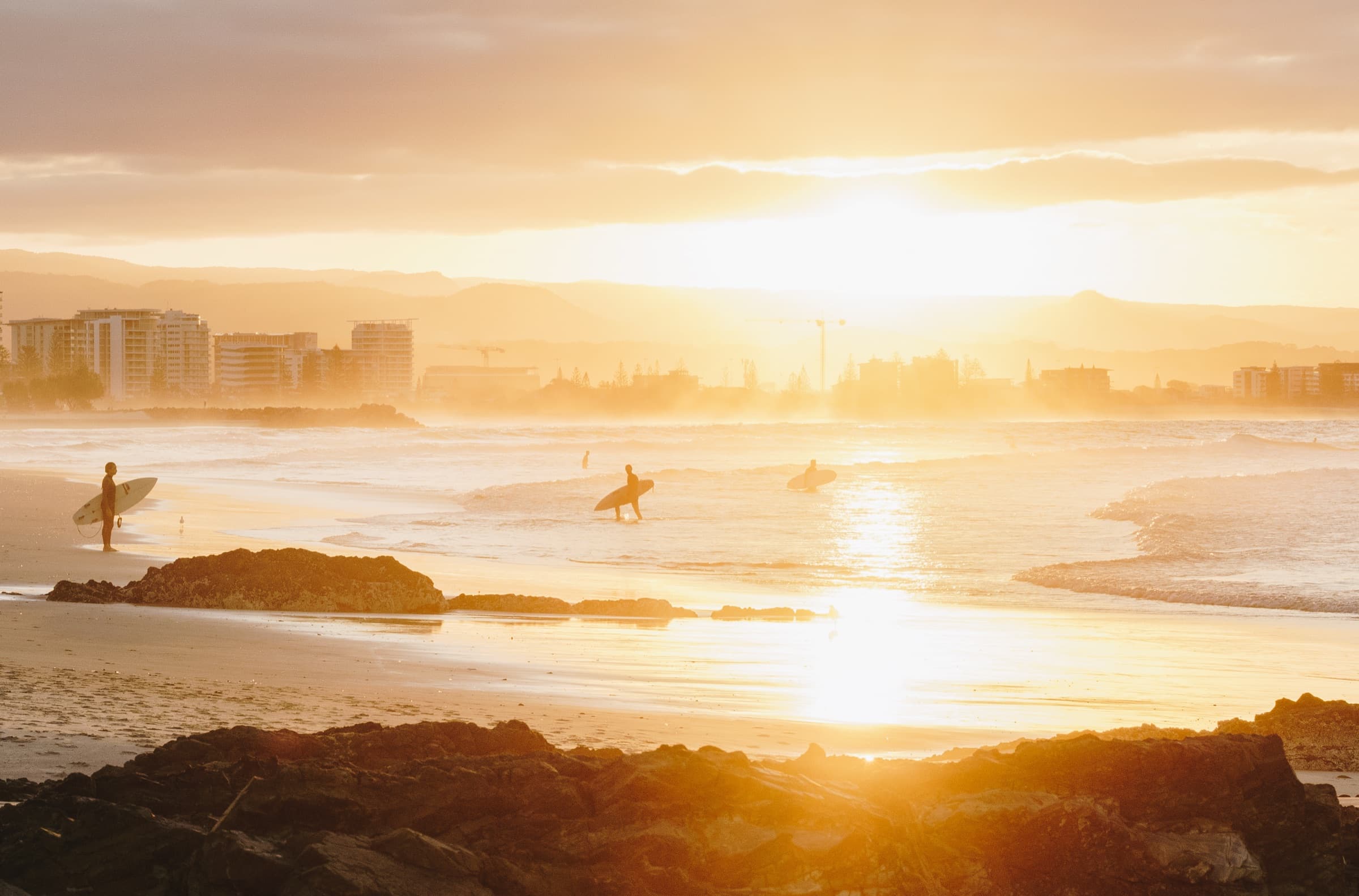 Surfers on the Gold Coast at sunset
